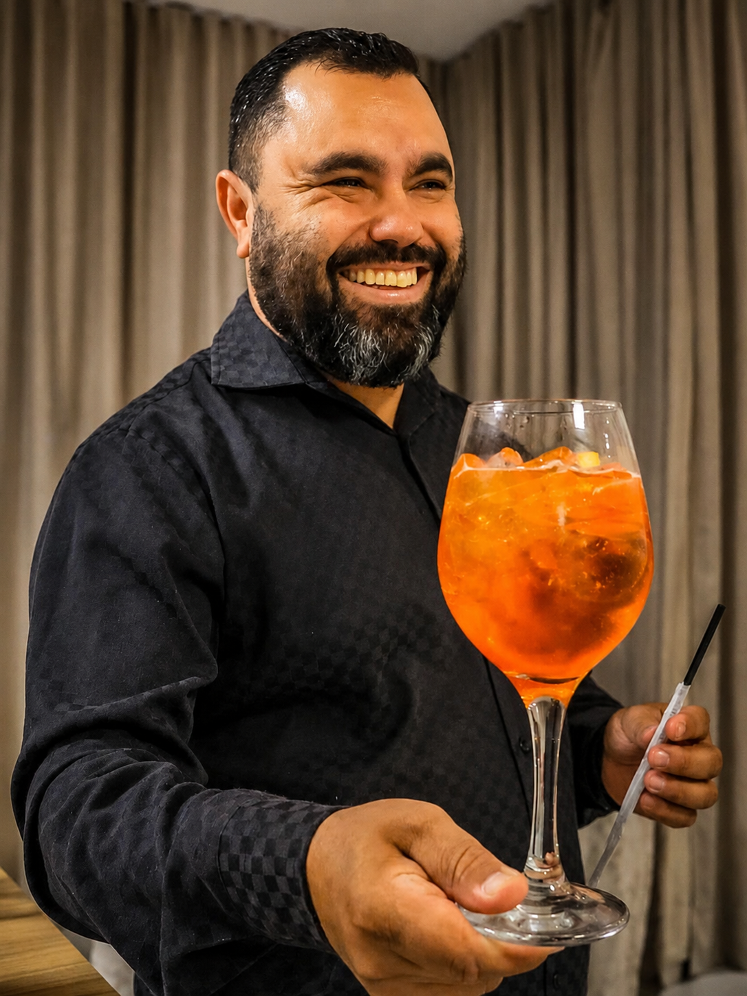 Tiago Ribeiro sorrindo e apresentando um drink